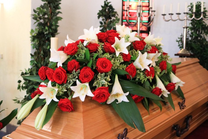Sargschmuck mit roten Rosen und weißen Lilien