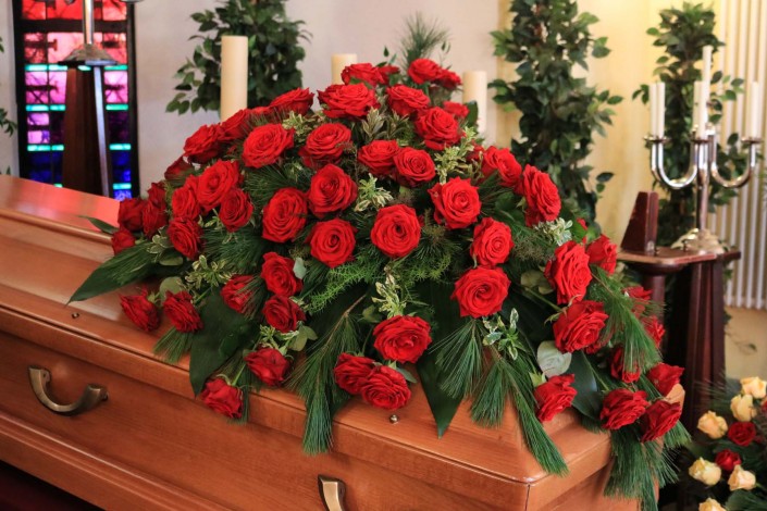 Sargschmuck mit roten Rosen